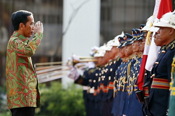Indonesian President Joko Widodo salutes the colors during a welcoming ceremony for Widodo at the Malacanang presidential palace in Manila February 9, 2015. Widodo will discuss with President Benigno Aquino matters of mutual concern, including migrant workers issues, maritime cooperation, defense, trade and investment, a foreign affairs press statement said.      REUTERS/Erik De Castro  (PHILIPPINES - Tags: POLITICS)